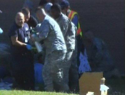 In this image made from Associated Press Television video, emergency personnel take a wounded person on a stretcher to an awaiting ambulance at the scene at the U.S. Army base in Fort Hood Texas where a soldier opened fire, unleashing a stream of gunfire that left at least 12 people dead and at least 31 wounded.(AP Photo/APTN)