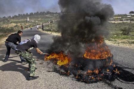 Palestinian protestors burn tyres during a protest against the confiscation of lands at the West Bank village of Nabi Salah in northern Ramallah, Feb. 12, 2010. (Xinhua/Fadi Arouri) 