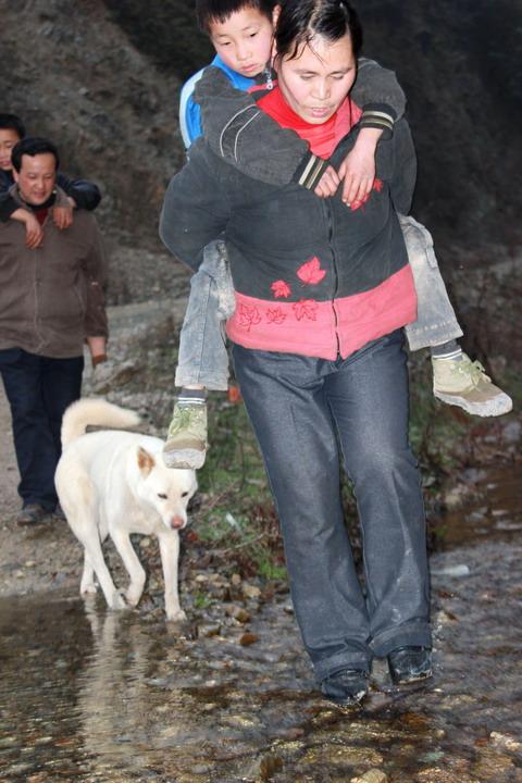 山洪爆發的時候，不管是颳風下雨還是寒來暑往，張令龍、姚本蓮夫婦都要背學生過河。