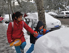 兩位小學生在上學路上玩雪