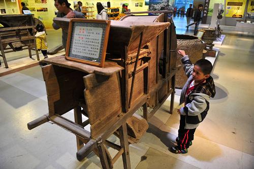   12月1日，一位小朋友在體驗廣西傳統農具——風谷機。