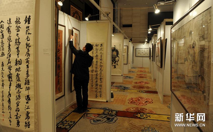 1月24日，一名工作人員在呼和浩特首屆文物藝術品拍賣會預展現場懸挂展品。 