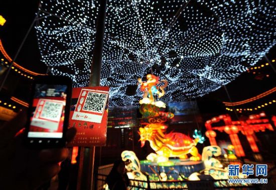 2月6日，市民在南京夫子廟裏的大型燈組前用手機刷二維碼，獲取祝福語。