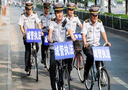 湖北新洲城管人員騎自行車上街流動執法。