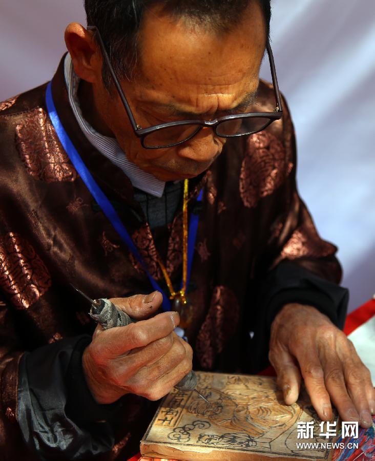  （2）1月21日，騰衝木刻工藝神馬製作坊的老藝人在現場展示祖傳雕刻技藝。