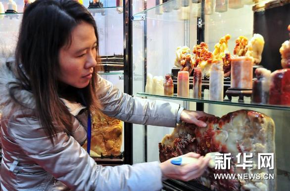     3月7日，來自福建的客商在擦拭壽山石雕件。新華網圖片 鄧華 攝