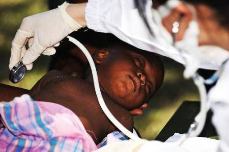 A Haitian child receives medical treatment at a makeshift hospital set up by a Chinese medical team in Port-au-Prince Jan. 27, 2010. The team will stay in Haiti for weeks to provide basic medical care for survivors of the Jan. 12 earthquake. (Xinhua Photo)