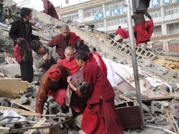 Local people succor the injured persons from the debris of crumbled houses shortly after an earthquake jolted at 7:49 a.m., at Gyegu Town, of Yushu, a Tibetan autonomous prefecture in western Qinghai Province of northwest China, April 14, 2010.(Xinhua/Zhang Hongshuan)