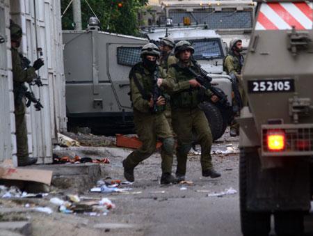 Israeli soldiers walk in the street to take positions during a raid in the West Bank city of Nablus, on Dec. 26, 2009.(Xinhua/Ayman Nobani)