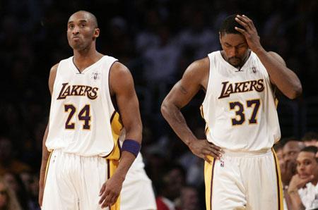 Los Angeles Lakers' Ron Artest (R) holds his head after being fouled by Cleveland Cavaliers' Zydrunas Ilgauskas, of Lithuania, as Kobe Bryant (L) walks next to him during the first half of their NBA basketball game in Los Angeles, December 25, 2009. (Xinhua/Reuters Photo)