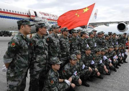 Members of the Chinese medical care and epidemic prevention team pose for a group photo at an airport in Port-au-Prince, capital of Haiti, on Jan. 25, 2010. The 40-member Chinese medical care and epidemic prevention team arrived in Haiti on Monday by a chartered flight, which also carried 20 tonnes of medical supplies. Four Chinese peacekeeping police officers also arrived in Haiti along with them to replace their four comrades dead in the recent earthquake. (Xinhua Photo)