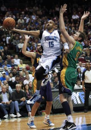 Orlando Magic guard Vince Carter (C) splits New Orleans Hornets forwards' Darius Songaila (R) and Peja Stojakovic as he goes to the basket during second half NBA basketball action in Orlando, Florida February 8, 2010. Magic won 123-117. (Xinhua/Reuters Photo)