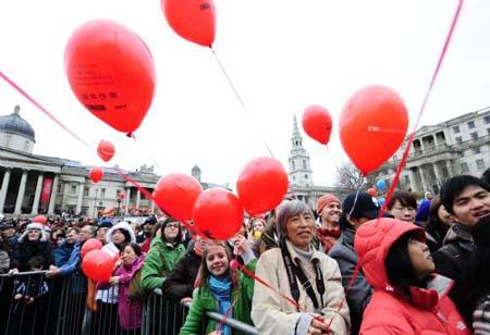 People watch the spectacular performances during a celebration of Chinese Lunar New Year on Trafalgar Square in London, capital of Britain, Feb. 21, 2010. Grand Chinese Lunar New Year celebrations were held in Trafalgar Square, Leicester Square and Chinatown in London on Sunday, providing a spectacular Chinese traditional festival experience to locals and visitors alike. (Xinhua/Zeng Yi)