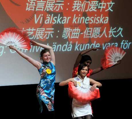 Three middle school students dance during the second "Chinese Bridge" Chinese language competition of Swedish middle school and university students in Stockholm, capital of Sweden, March 14, 2010. Nine university students and 33 middle school students took part in the competition on Sunday. (Xinhua/He Miao)