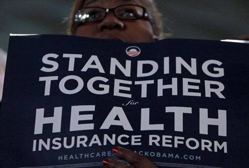 A woman listens to U.S. President Barack Obama deliver remarks on health insurance reform at St. Charles High School in St. Louis, Missouri, March 10, 2010. (Xinhua/Reuters File Photo)