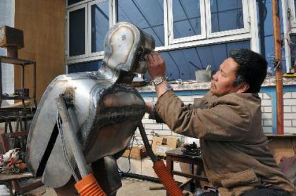 Wu Yulu works on an unfinished robot at home in Mawu village, suburban of Beijing, on March 16, 2010. Wu, a local farmer who has made 38 robots in past decades, was recently invited to make robots for the upcoming 2010 Shanghai World Expo. (Xinhua/He Junchang)