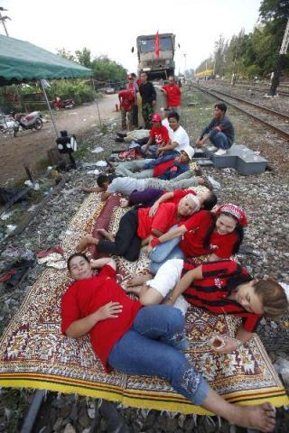 Anti-government 'red shirt' supporters block a train carrying military supplies in Khon Kaen province, located in the north east of Thailand on April 22, 2010. A freight train carrying military vehicles and equipment has been held up by the red shirts in Khon Kaen province, the Bangkok Post reported police saying. (Xinhua/Reuters Photo)