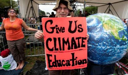 A man holds a cardboard written with Give Us Climate Education at a concert named Climate Rally at the National Mall in Washington D.C, capital of the United States, April 25, 2010. The Climate Rally was held Sunday to honor the Earth Day that falls on April 22 and call for fighting against climate change. (Xinhua/Zhu Wei)