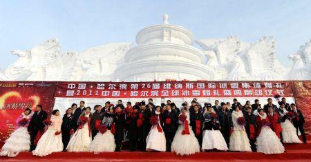 Newly wedded couples pose for photos in front of a snow sculpture during a group wedding ceremony at the 26th Harbin International Ice and Snow Festival in Harbin, Heilongjiang Province January 6, 2010. A total of 28 couples from China and abroad participated in the ceremony.(Xinhua/Li Yong)