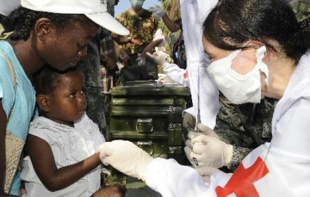 A member of a Chinese medical team asks about a child's symptoms at a makeshift hospital that the team has set up in Port-au-Prince Jan. 27, 2010. The team will stay in Haiti for weeks to provide basic medical care for survivors of the Jan. 12 earthquake. (Xinhua Photo)