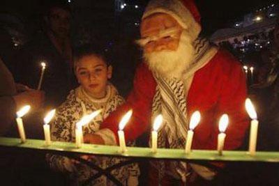 Palestinians light candles during preparations to celebrate Christmas in the West Bank city of Ramallah December 19, 2009.REUTERS/Mohamad Torokman