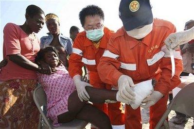 In this photo released by China's Xinhua News Agency, medical workers of China's International Search and Rescue Team (CISAR) treat a woman's wounded foot in Port-au-Prince, Haiti, Monday, Jan. 18, 2010.(AP Photo/Xinhua, Yuan Man)