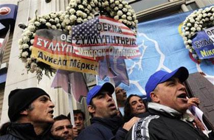 Members of Greece's main GSEE trade union hold a mock funeral with a coffin standing for the Greek economy surrounded by wreaths from Greece's international partners in central Athens on Wednesday, March 10, 2010. (AP Photo/Marita Pappa)