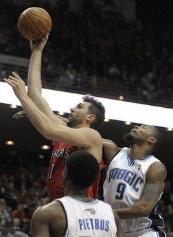 Toronto Raptors center Andrea Bargnani, left, of Italy, goes up for a shot in front of Orlando Magic guard Mickael Pietrus, of France, and Rashard Lewis, right, during the first half of an NBA basketball game in Orlando, Fla., Wednesday, Jan. 6, 2010.(AP Photo/Phelan M. Ebenhack)