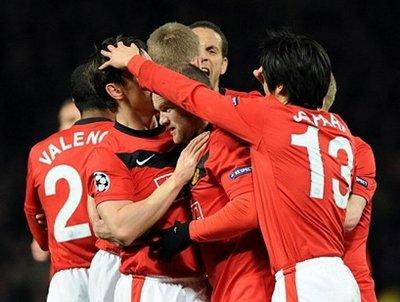 Manchester celebration : Manchester United's English forward Wayne Rooney is congratulated after scoring against AC Milan during their UEFA Champions League round of 16, second leg football match at Old Trafford in Manchester. Manchester won 4-0.(AFP/Giuseppe Cacace)