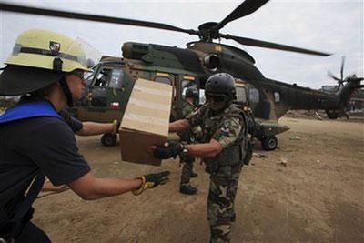 Troops and firefighters unload aid from a military helicopter in Dichato, Chile, Wednesday, March 3, 2010. (AP Photo/Ricardo Mazalan)