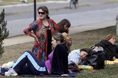 People wait outside their homes after an aftershock in Talcahuano, Chile, Thursday, March 11, 2010. (AP Photo/Silvia Izquierdo)