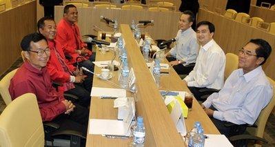 Thailand's Prime Minister Abhisit Vejjajiva, second right, Chamni Sakdiset, Democrat Party deputy secretary-general, far right, and Kobsak Sabhavasu, secretary of prime minister's office, third right, talk with anti-government leaders Weng Tojirakarn, from left, Veera Muksikapong and Jatuporn Prompan during their negotiation to find a way to restore peace and minimize the chance of violence in Bangkok, Thailand, Monday, March 29, 2010.(AP photo/Sakchai Lalit)