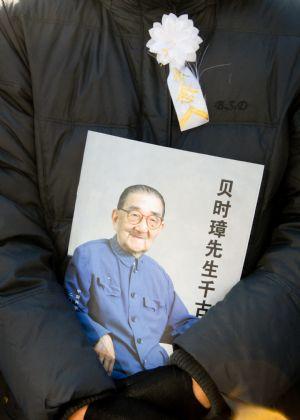 A mourner holding a portrait of Bei Shizhang pays his respect to Bei Shizhang during the farewell ceremony at the Babaoshan Revolutionary Cemetery in Beijing, capital of China, Nov. 4, 2009. Bei Shizhang, considered as the 