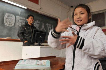 Deaf-mute pupil Cheng Huawen (R) uses dactylology to express her understanding of World Disability Day at class in Guiyang, capital of southwest China's Guizhou Province, Dec. 3, 2009.Activities were held on Dec. 3 all over China to mark the 18th World Disability Day.(Xinhua/Ou Dongqu)