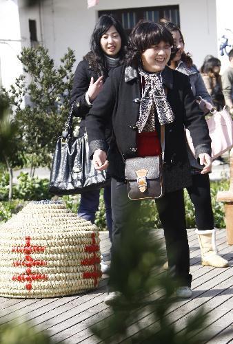 Tourists play games at Farmhouse Homestays of Expo in Shanghai, east China, March 13, 2010. Farmhouse of the Shanghai World Expo, served as eco-friendly countryside temporary "hotel" or "inn" during the Shanghai World Expo by virtue of rural advantageous tourist resources, entered district of suburban Shanghai for the first time. (Xinhua/Pei Xin)