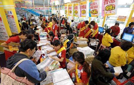 People regester for touring parties at the Guangzhou international tourism exhibition in Guangzhou, capital of south China's Guangdong Province, March 25, 2010. 2010 Guangzhou international tourism exhibition kicked off on Thursday. [Photo:Xinhua] 