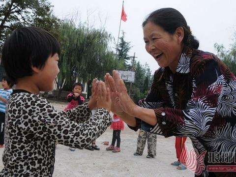 賈玉玲在和孩子們一起在學校操場上做遊戲