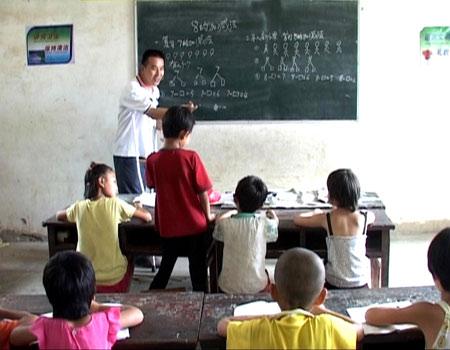 賈曉波持柺棍給小學生上課