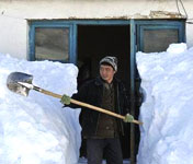 哈薩克族青年帕拉提在清掃自家庭院的積雪