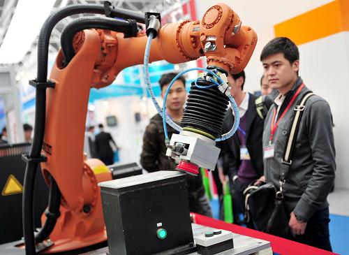 3月29日，一台機器人在首屆中國國際進口産品博覽會上進行工業品柔性磨邊演示。 