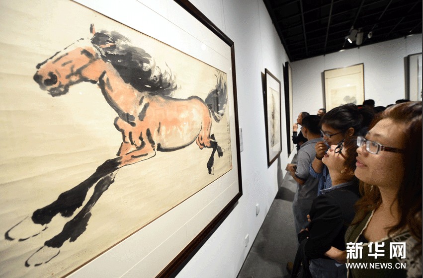 觀眾在欣賞徐悲鴻創作的國畫《大紅馬圖》。