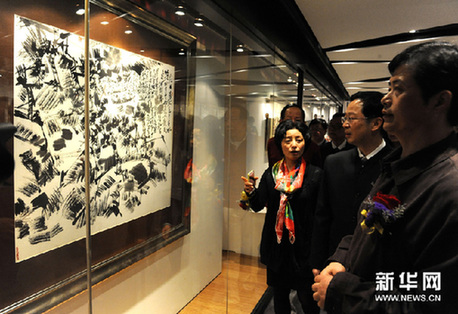 3月4日，借院（右）在藝術展上陪同嘉賓觀看其作品。新華網圖片 黃本強 攝