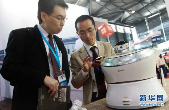 3月19日，一名工作人員（右）向參觀者演示一台可以通過手機遙控的空氣凈化器。新華社記者裴鑫攝
