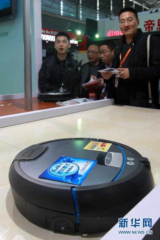 3月19日，參觀者在博覽會上觀看一台清掃機器人的功能展示。新華社記者裴鑫攝