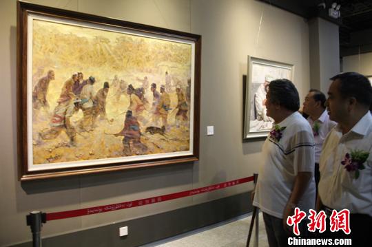 18日，“向上•新疆油畫作品學術展”開幕。一幅反應南疆少數民族農民打曲棍球的油畫吸引了參觀者。　朱景朝　攝
