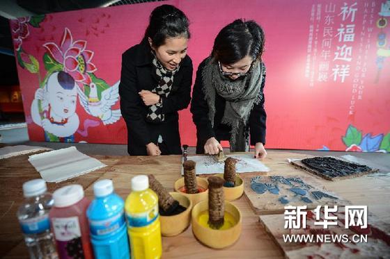     1月1日，參觀者親手體驗用木刻版印製傳統年畫。新華網圖片 徐昱 攝