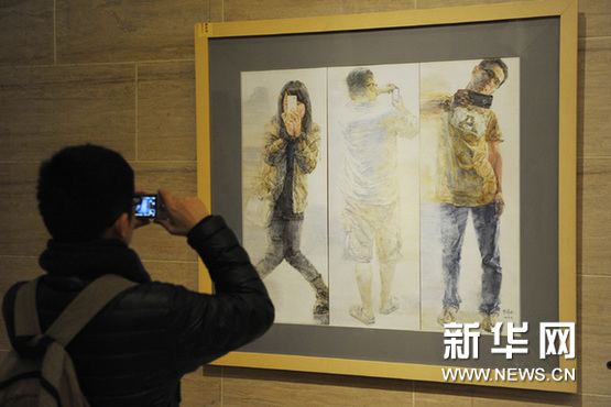    1月15日，一名出席展覽新聞會的記者在中國美術館拍攝一幅即將展出的繪畫作品。新華網圖片 魯鵬 攝