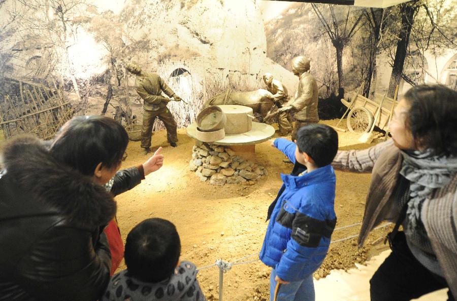   （2）1月21日，在“尋根·守望——沐浴聖地洗禮的北京知青”專題展上，北京老知青在向孫子介紹自己當年在延安的生活經歷。
