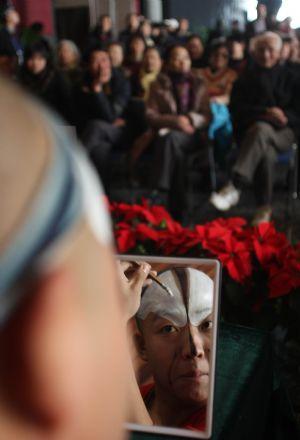 A performer displays the process of Beijing Opera's make-up during the open day at the National Center for the Performing Arts (NCPA), or the National Grand Theater, in Beijing, capital of China, Dec. 22, 2009. (Xinhua/Luo Xiaoguang)