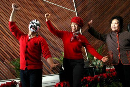 Two visitors learn to pose under the direction of a Beijing Opera performer during the open day at the National Center for the Performing Arts (NCPA), or the National Grand Theater, in Beijing, capital of China, Dec. 22, 2009. (Xinhua/Luo Xiaoguang)